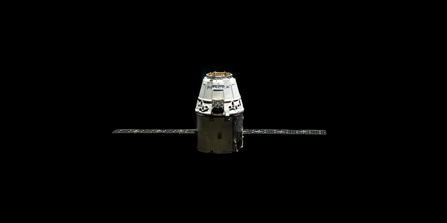 A SpaceX Dragon capsule orbited against the dark vastness of outer space.