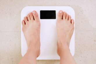 person standing on white digital bathroom scale