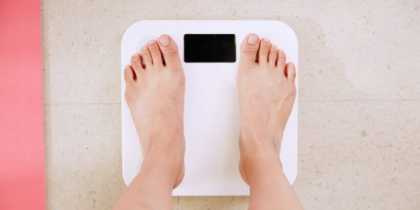 person standing on white digital bathroom scale