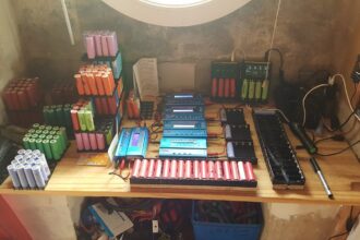 Glubux assembling laptop battery packs inside his workshop for his long-running DIY solar power system