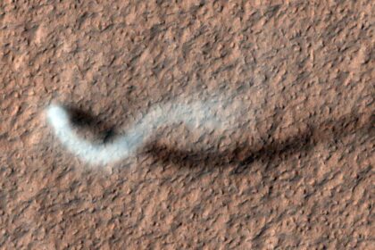 Tall dust devil twisting across the Martian surface, captured by Mars Reconnaissance Orbiter.
