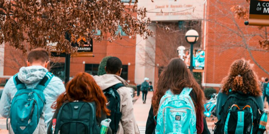 A group of college students with backpacks walking together outdoors on campus.