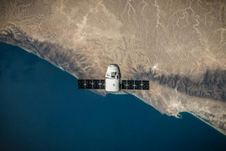A satellite hovering above Earth's coastline, captured from space.